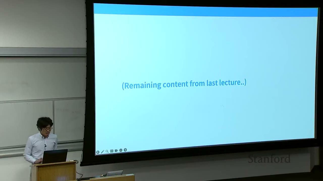 A speaker at a podium, with a slide titled "Remaining content from last lecture.."